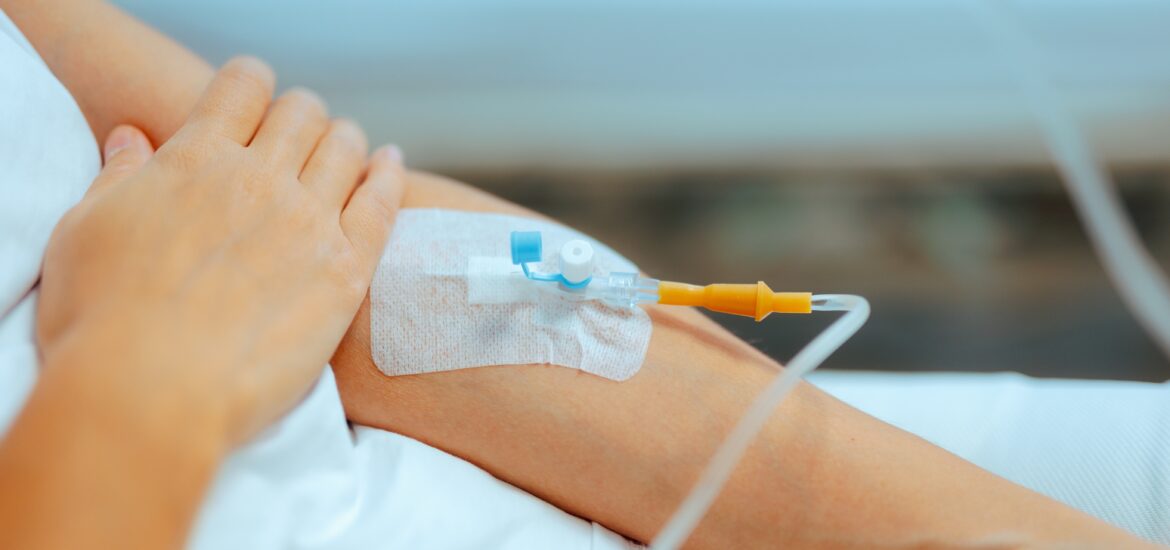 dental patient's left arm with an IV needle going in for sedation